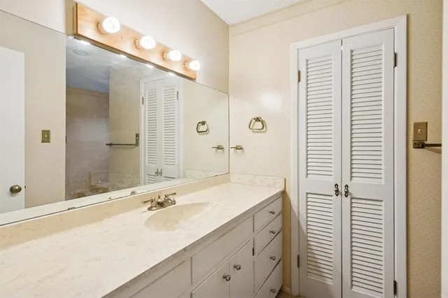 a bathroom with a shower sink and mirror