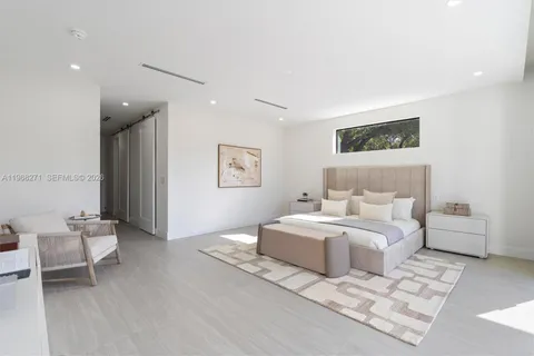 a spacious bedroom with a bed and a chair