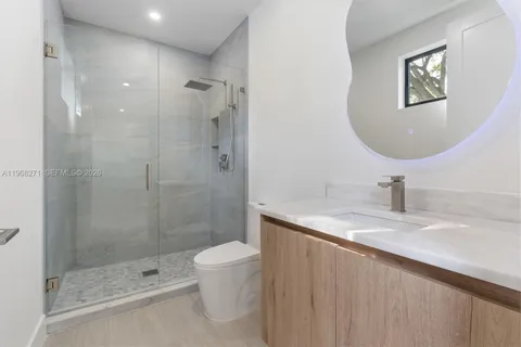 a bathroom with a granite countertop sink a toilet and shower