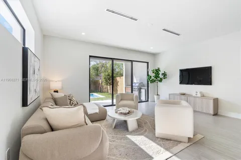 a living room with furniture a flat screen tv and a large window