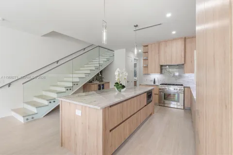 a kitchen with stainless steel appliances kitchen island granite countertop a sink and a stove top oven