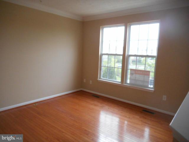 9744 Luguna Road Baltimore, MD 21220 - Photo 3 of 30 a view of an empty room with wooden floor and a window