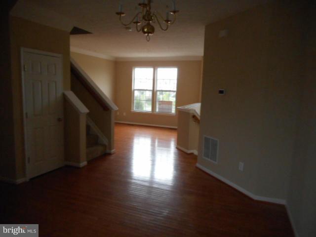 9744 Luguna Road Baltimore, MD 21220 - Photo 8 of 30 a view of empty room with wooden floor and fan