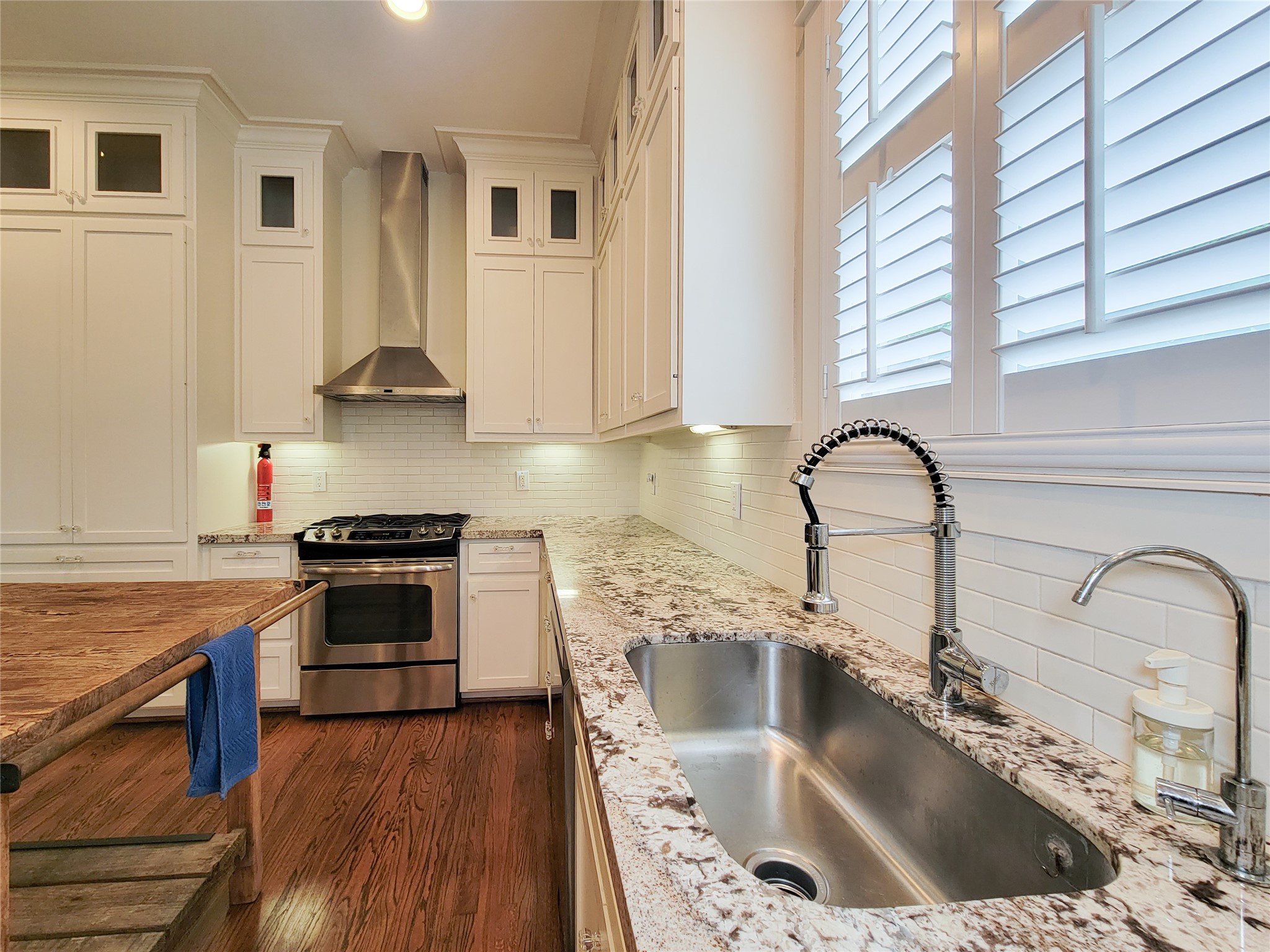1140 West Cottage Street Houston, TX 77009 - Photo 19 of 37 a kitchen with stainless steel appliances granite countertop a sink stove and cabinets