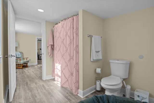 a bathroom with a toilet sink and shower curtain