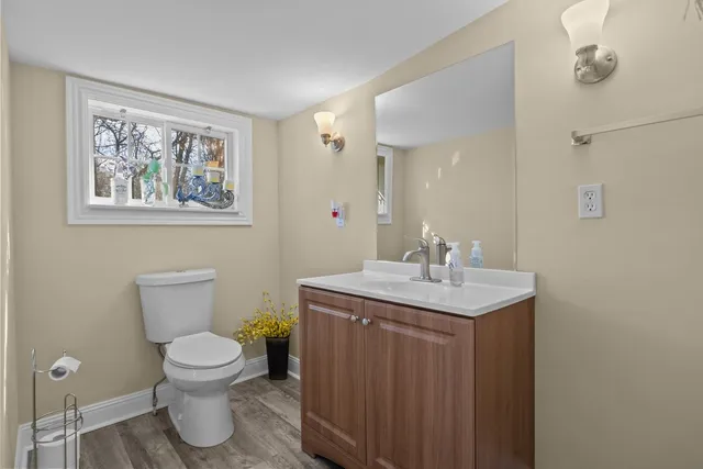 a bathroom with a granite countertop toilet and a sink