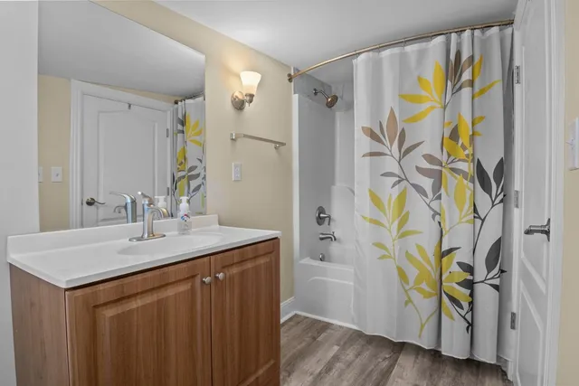 a bathroom with a granite countertop sink a mirror and a shower
