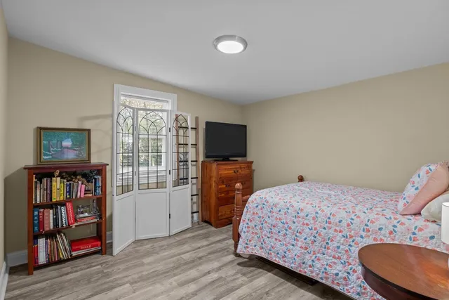 a bedroom with a bed furniture and a flat tv screen