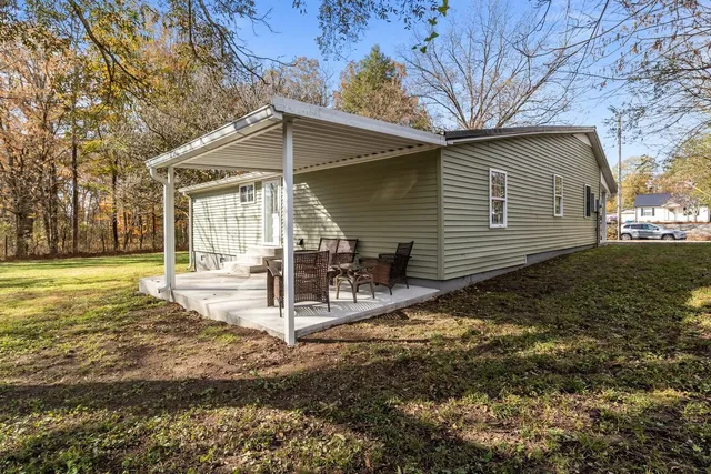 a view of a house with backyard and a tree