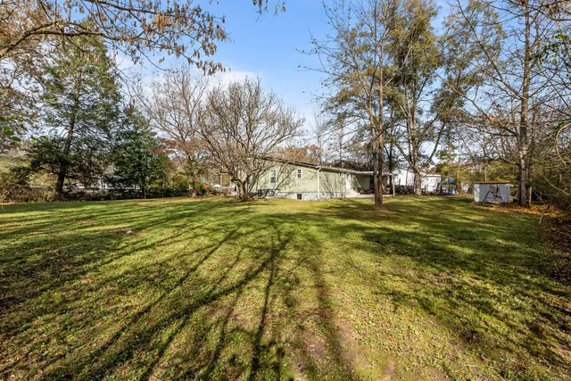 a view of a field with trees in front of it