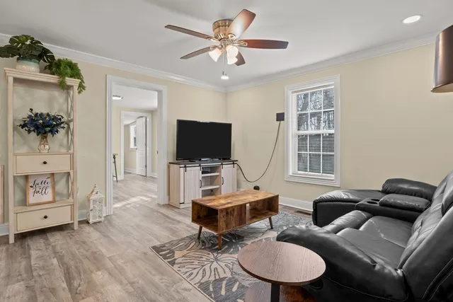 a living room with furniture a flat screen tv and a window