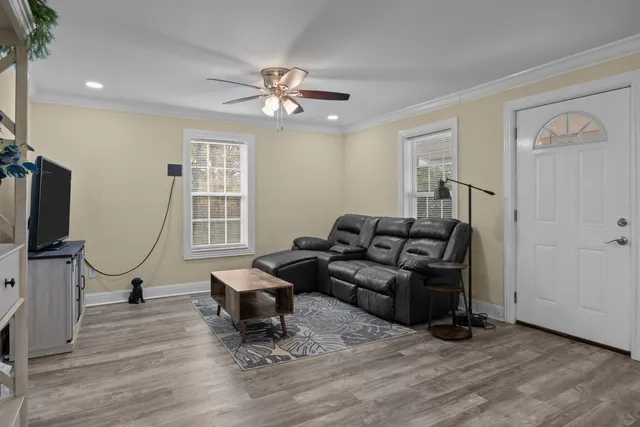 a living room with furniture a window and a flat screen tv