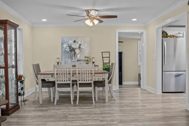 a dining room with furniture a chandelier and wooden floor