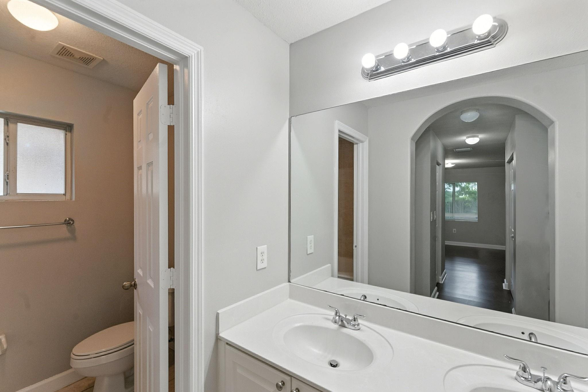 25355 Southwest 135th Court Homestead, FL 33032 - Photo 19 of 40 a bathroom with a toilet a sink and mirror