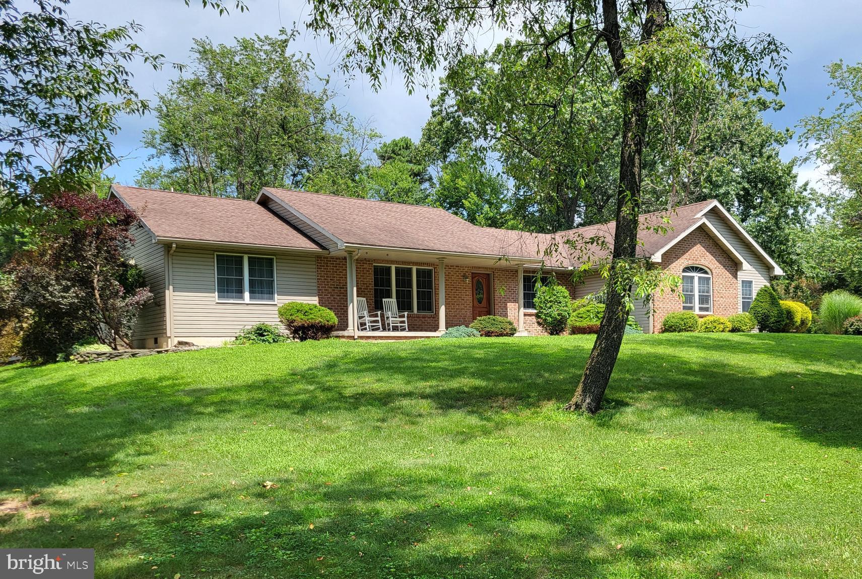 a front view of a house with a yard and trees