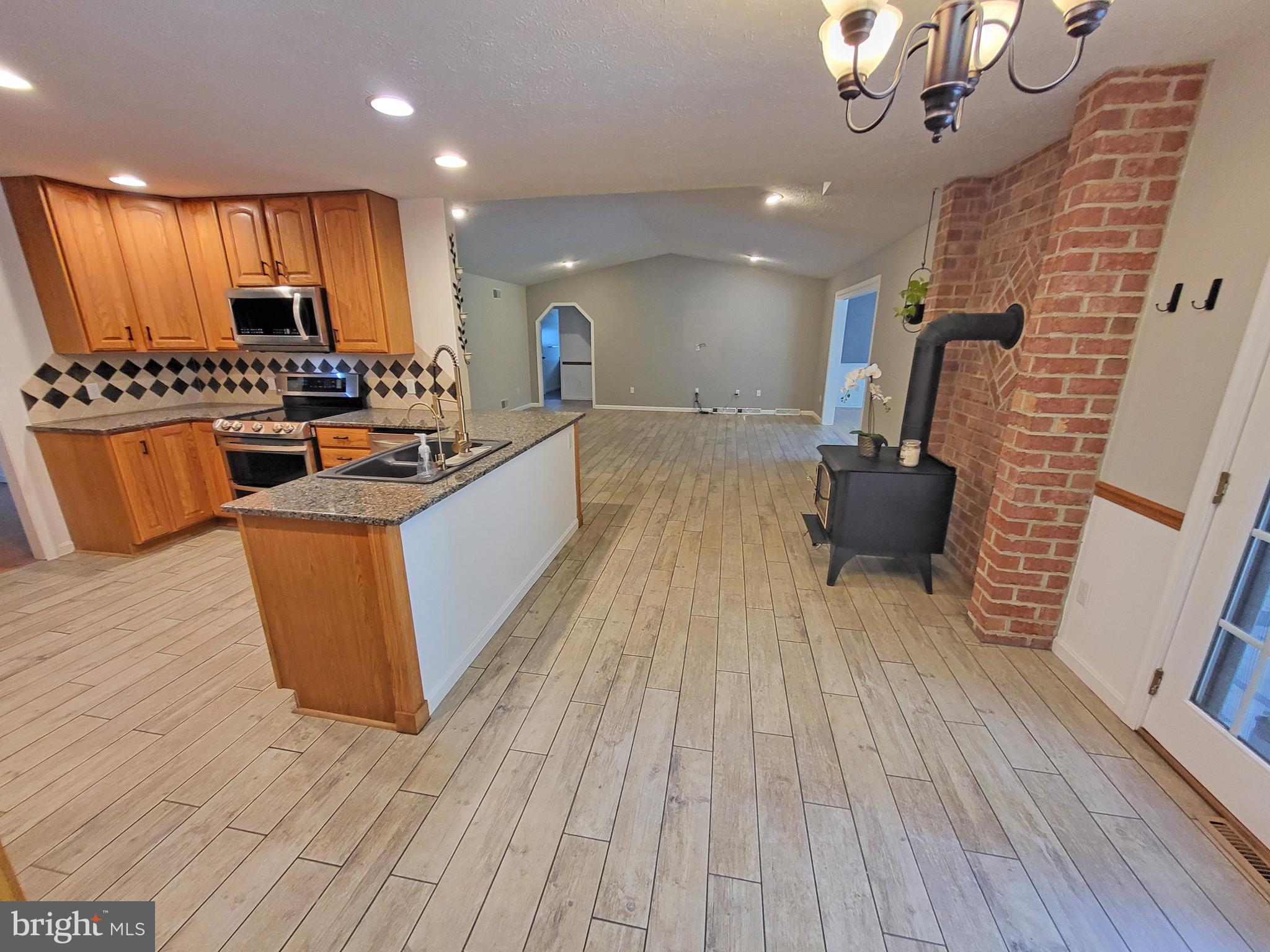 212 Walnut Dale Road Shippensburg, PA 17257 - Photo 15 of 56 a large kitchen with stainless steel appliances a large counter top a stove and a wooden floors