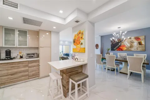 a room with furniture a chandelier a sink and kitchen view