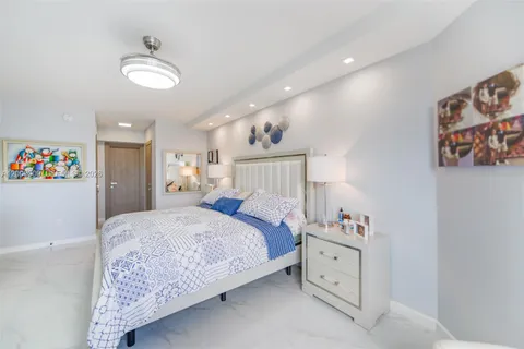 a spacious bedroom with a bed and a chandelier