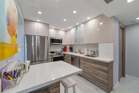 a kitchen with kitchen island a stove a sink and a refrigerator