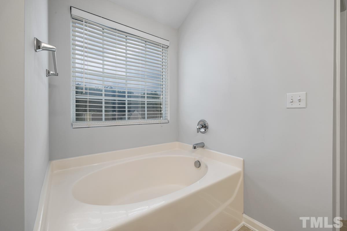 3739 Burtons Barn Street Raleigh, NC 27610 - Photo 30 of 42 a white bath tub sitting next to a window