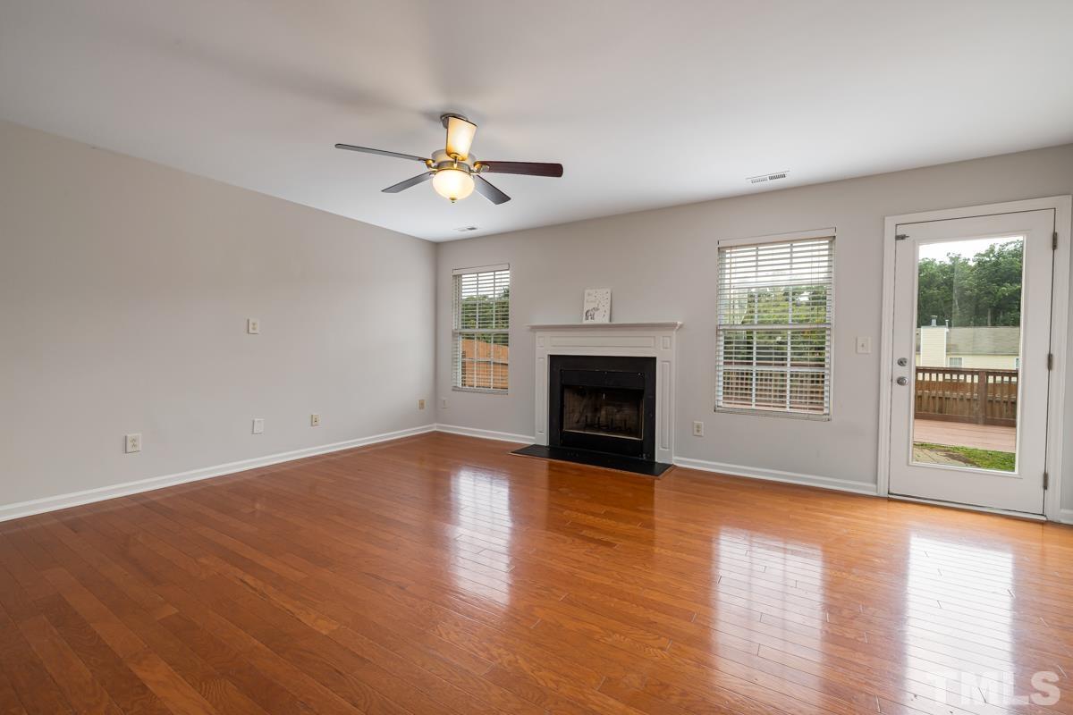 3739 Burtons Barn Street Raleigh, NC 27610 - Photo 8 of 42 an empty room with windows fireplace and a kitchen view