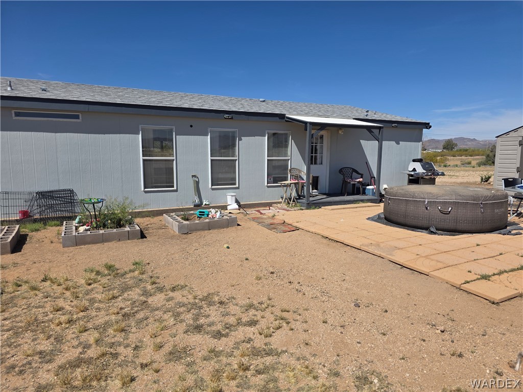 4182 Canelo Road Golden Valley, AZ 86413 - Photo 5 of 31 The property features a light-colored exterior with a grey roof, several windows, and a covered patio area