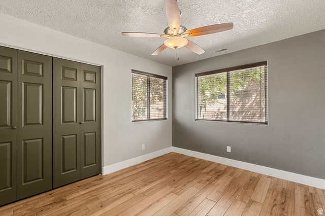 55 Spring Drive Toquerville, UT 84774 - Photo 21 of 36 Unfurnished bedroom 4 with light wood finished floors, a closet, a ceiling fan, and a textured ceiling