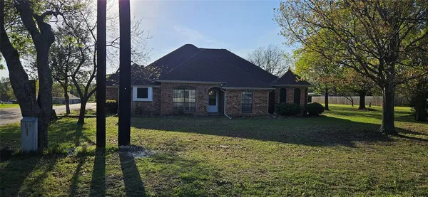 a front view of a house with a yard and trees