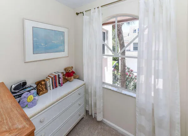 a bedroom with a bed tv and a window