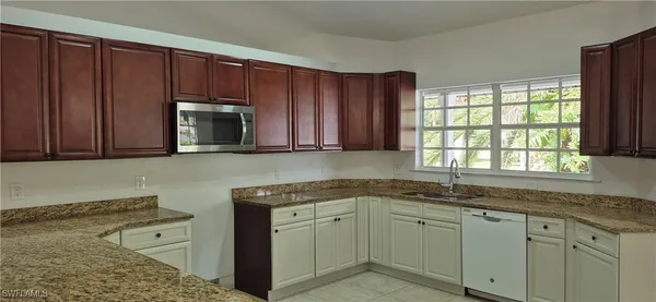 a bathroom with a granite countertop shower a sink and a mirror