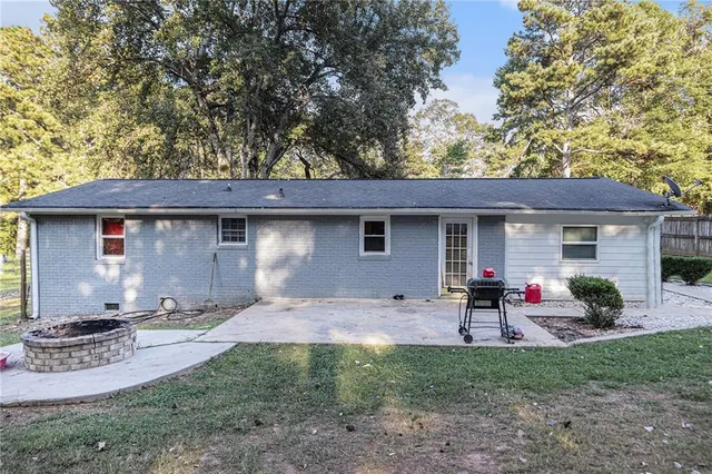 a backyard of a house with table and chairs