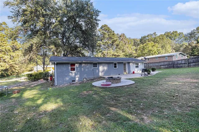 a view of house with backyard and seating area
