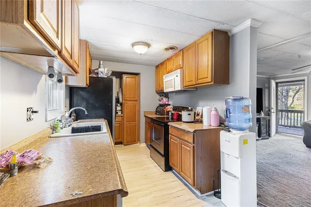 a kitchen that has a lot of cabinets a sink and a wooden floor