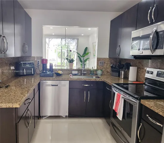 a kitchen with stainless steel appliances granite countertop a sink stove and cabinets