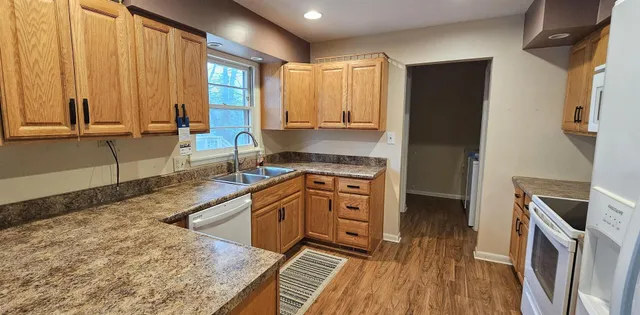 a kitchen with granite countertop a stove a sink and a refrigerator