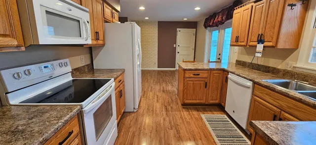 a kitchen with stainless steel appliances granite countertop a stove a sink and a refrigerator
