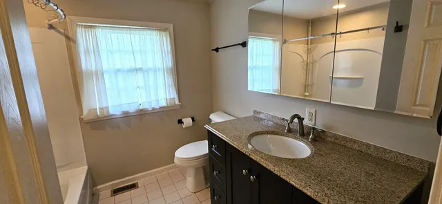 a bathroom with a granite countertop sink and a mirror