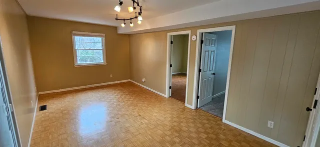 wooden floor in an empty room with a window
