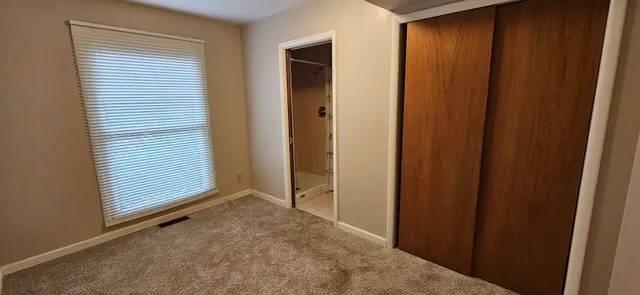 an empty room with window and closet