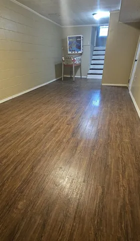 an empty room with wooden floor and furniture