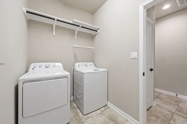 a large kitchen with stainless steel appliances a large counter top a stove and a refrigerator