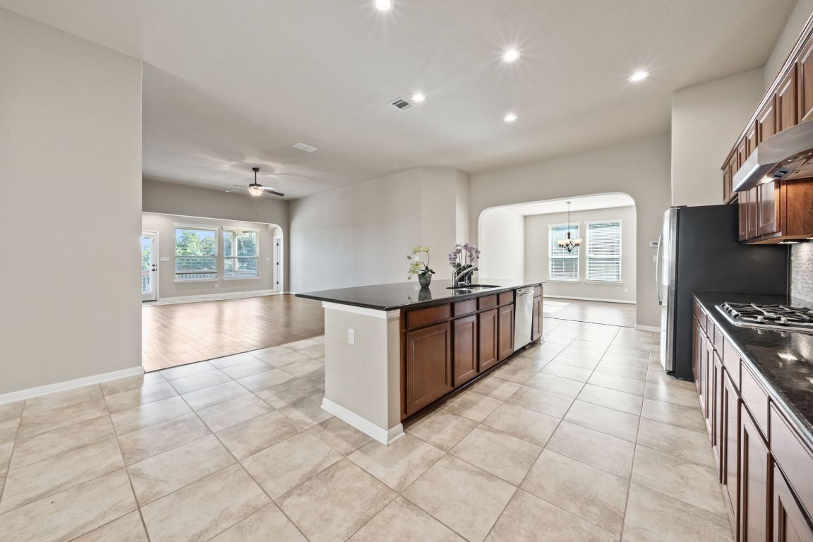 209 Rock Vista Run Austin, TX 78737 - Photo 16 of 40 a large kitchen with stainless steel appliances a large counter top a stove and a refrigerator