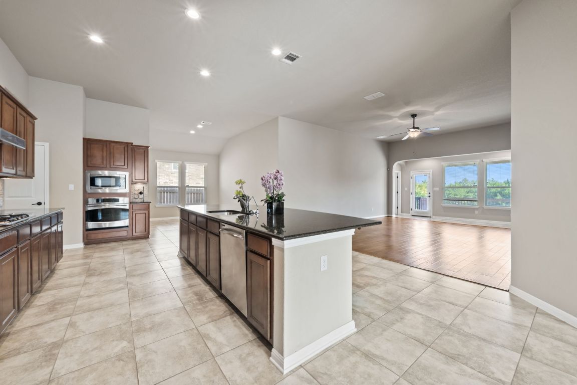 209 Rock Vista Run Austin, TX 78737 - Photo 17 of 40 a kitchen with stainless steel appliances granite countertop a stove top oven a sink a counter top space and cabinets