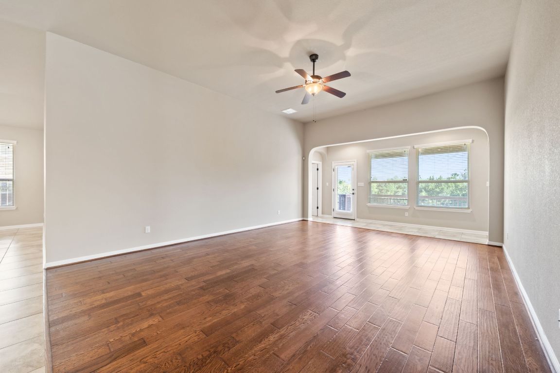 209 Rock Vista Run Austin, TX 78737 - Photo 24 of 40 an empty room with wooden floor fan and windows