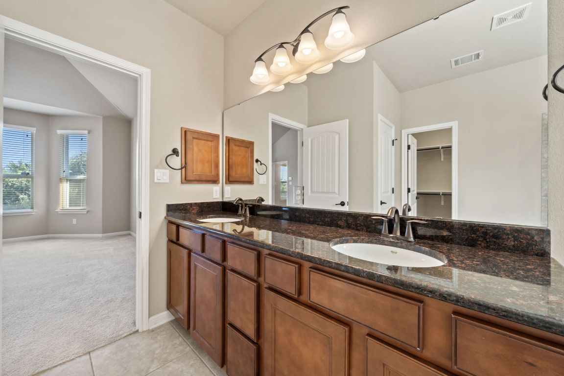 209 Rock Vista Run Austin, TX 78737 - Photo 25 of 40 a bathroom with a granite countertop double vanity sink and a mirror