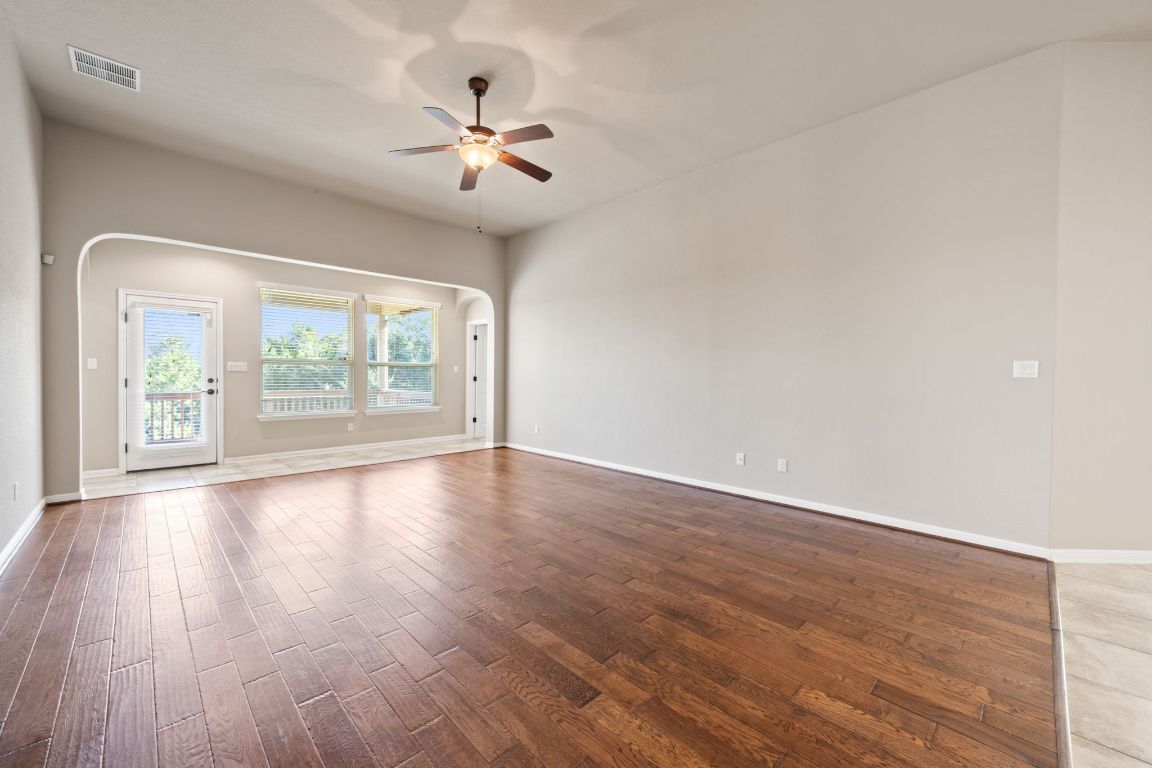 209 Rock Vista Run Austin, TX 78737 - Photo 4 of 40 a view of an empty room with wooden floor and a window