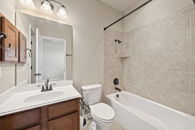 a large kitchen with stainless steel appliances a large counter top a stove and a refrigerator