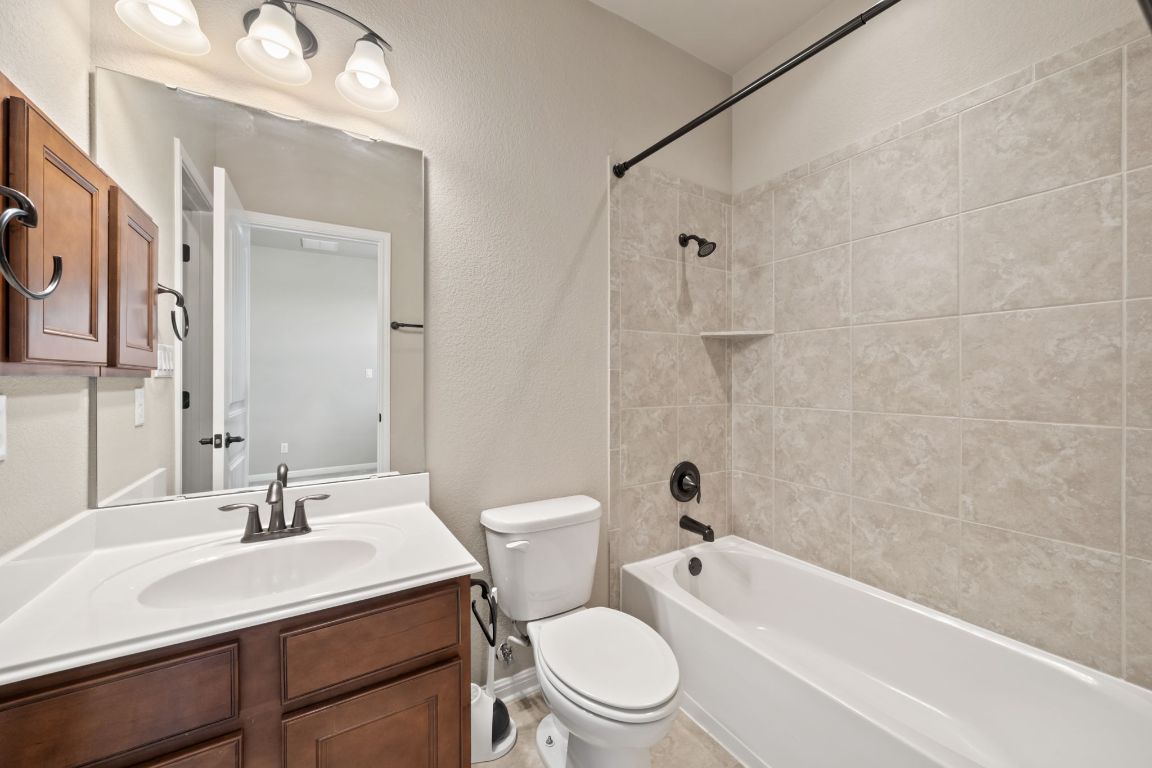 209 Rock Vista Run Austin, TX 78737 - Photo 9 of 40 a bathroom with a sink a toilet a mirror and shower