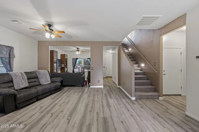 a living room with furniture and a wooden floor