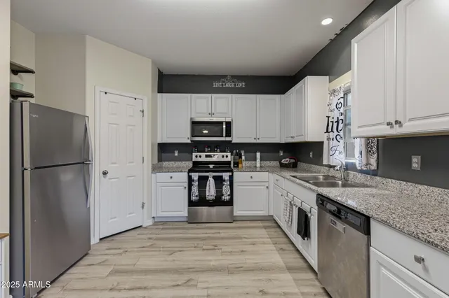 a kitchen with stainless steel appliances granite countertop a refrigerator sink and stove
